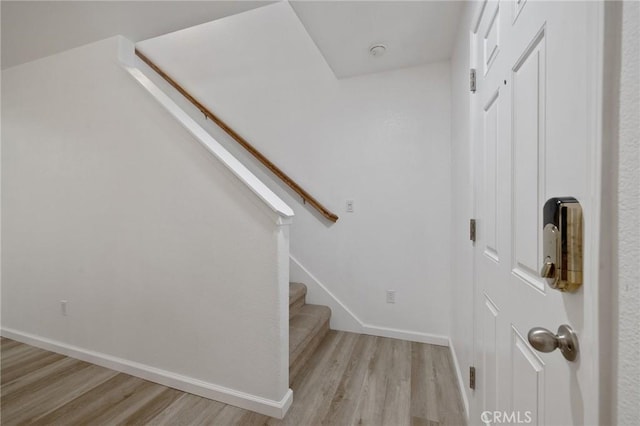 stairway with baseboards and wood finished floors