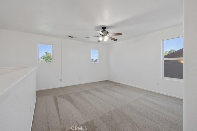 empty room with visible vents, ceiling fan, carpet flooring, and baseboards