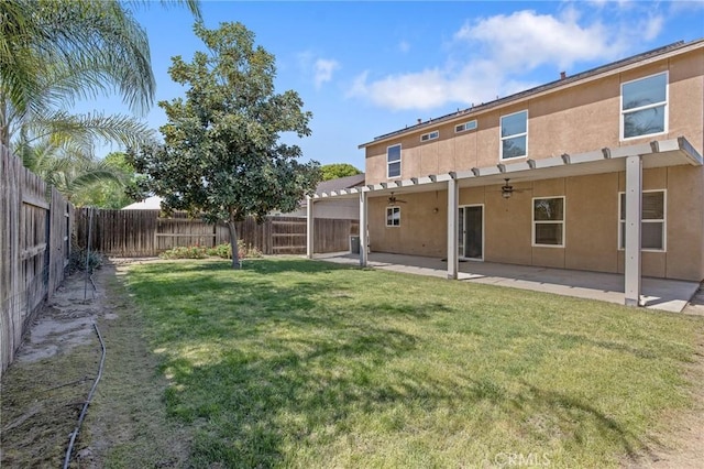 rear view of house with a fenced backyard, stucco siding, a yard, ceiling fan, and a patio area