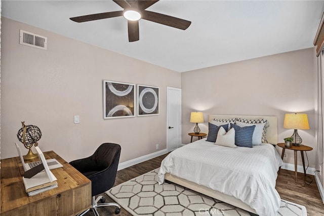 bedroom featuring wood finished floors, visible vents, a ceiling fan, and baseboards