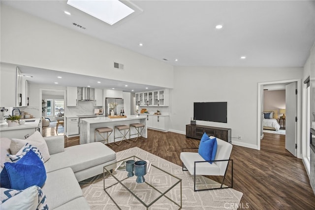living room featuring dark wood-style flooring, visible vents, recessed lighting, and baseboards