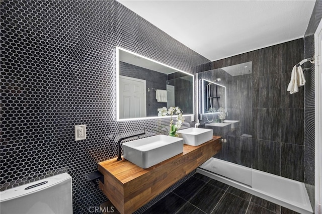 bathroom with a walk in shower, toilet, a sink, and tile walls