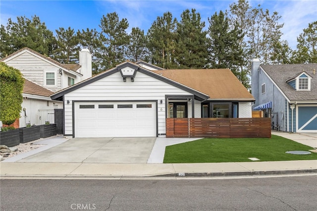 ranch-style home featuring concrete driveway, a front yard, an attached garage, and fence
