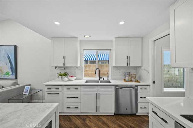 kitchen featuring tasteful backsplash, dishwasher, light countertops, and a sink