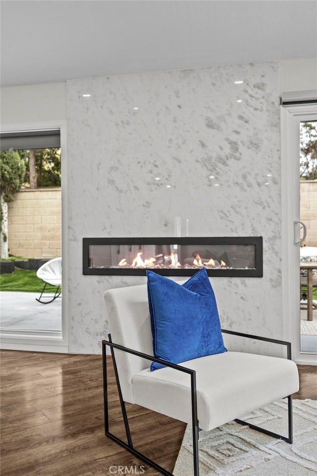 sitting room with a premium fireplace and wood finished floors