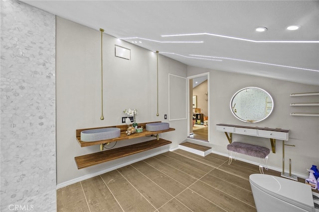 interior space featuring lofted ceiling, wood finished floors, toilet, and recessed lighting