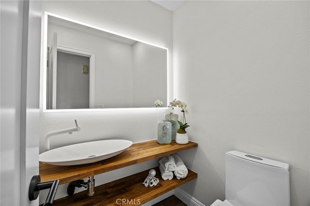 half bathroom featuring toilet and a sink