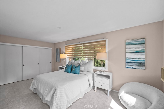 carpeted bedroom featuring a closet and baseboards