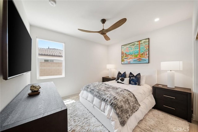 bedroom featuring baseboards, ceiling fan, and light carpet