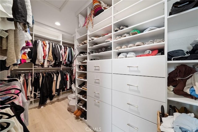 walk in closet with attic access and wood finished floors