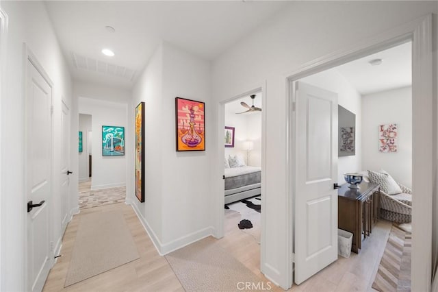 hallway with recessed lighting, baseboards, visible vents, and light wood-style flooring