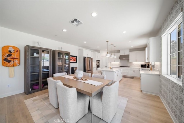 dining room featuring recessed lighting, baseboards, visible vents, and light wood-type flooring