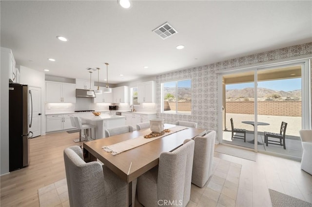 dining space with recessed lighting, wallpapered walls, visible vents, and light wood finished floors