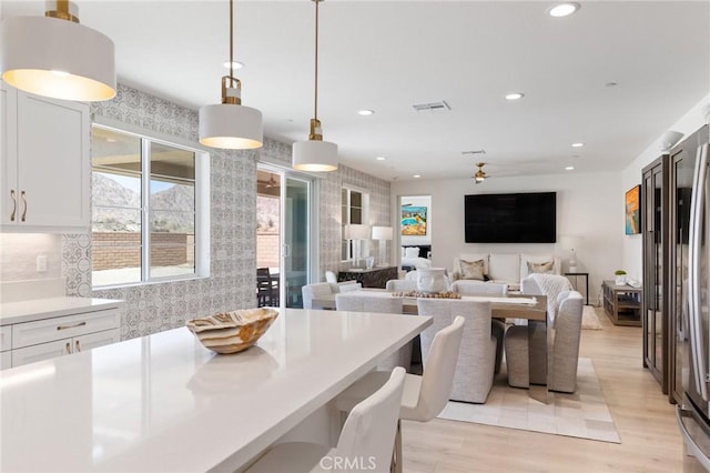 dining area with light wood-style floors, recessed lighting, ceiling fan, and visible vents