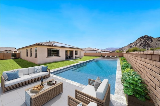 view of pool with a patio area, a mountain view, a fenced backyard, a yard, and outdoor lounge area