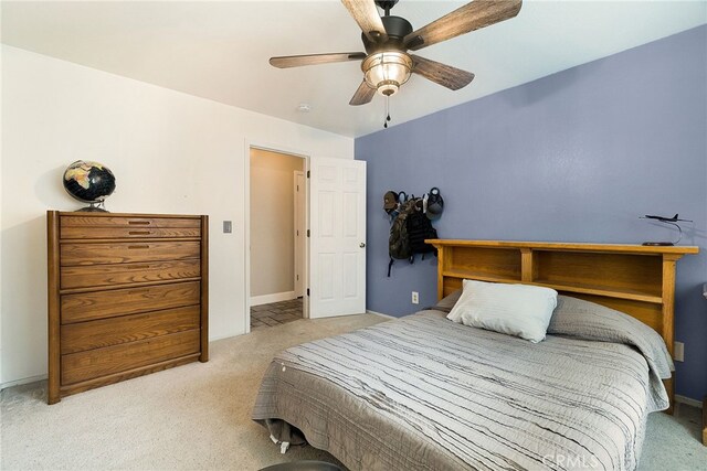 bedroom with a ceiling fan, light colored carpet, and baseboards