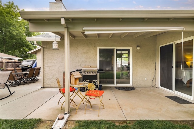 view of patio featuring a grill and fence
