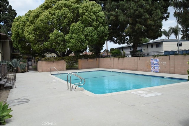 community pool featuring fence and a patio