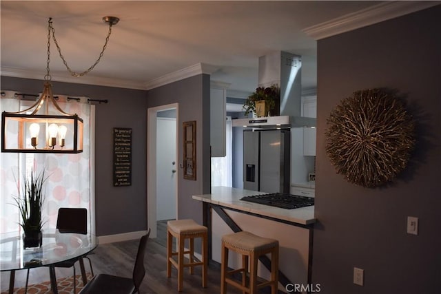 dining room with an inviting chandelier, ornamental molding, dark wood-style floors, and baseboards
