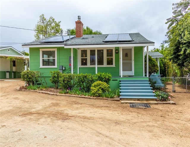 20095 Gustin Rd, Perris, CA 92570 - rear view of property with fence, roof with shingles, roof mounted solar panels, a chimney, and covered porch