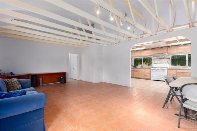 20095 Gustin Rd, Perris, CA 92570 - living area with arched walkways, rail lighting, vaulted ceiling with beams, and light tile patterned flooring