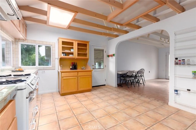 20095 Gustin Rd, Perris, CA 92570 - kitchen featuring light tile patterned flooring, light brown cabinets, arched walkways, tile counters, and white gas range