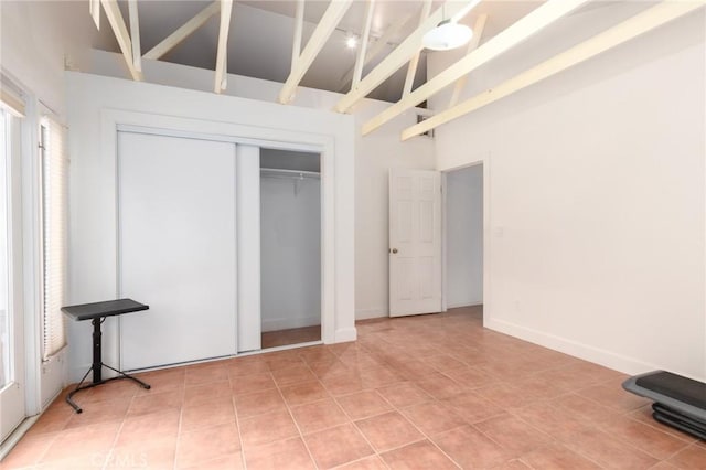 20095 Gustin Rd, Perris, CA 92570 - unfurnished bedroom featuring light tile patterned flooring, high vaulted ceiling, beam ceiling, and a closet