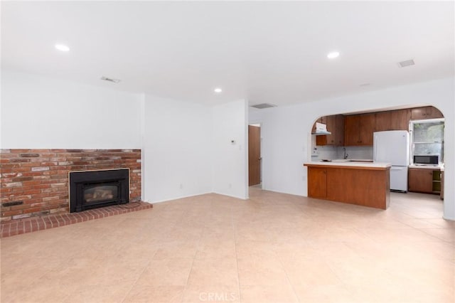 20095 Gustin Rd, Perris, CA 92570 - unfurnished living room featuring visible vents, a brick fireplace, recessed lighting, arched walkways, and light tile patterned floors