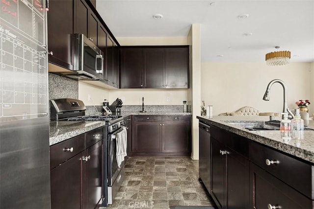 kitchen with light stone counters, stainless steel appliances, dark brown cabinets, and a sink