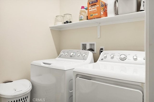 clothes washing area featuring separate washer and dryer and laundry area