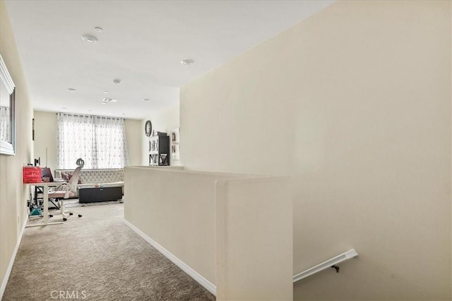 corridor with carpet and baseboards