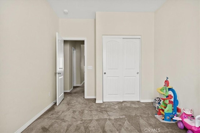 interior space with carpet, a closet, and baseboards