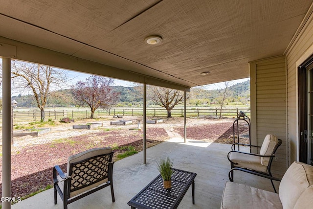 view of patio featuring a mountain view and fence