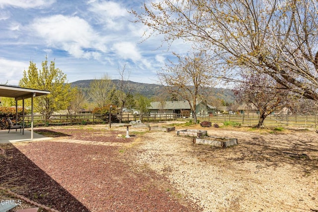 view of home's community featuring fence, a patio, and a mountain view