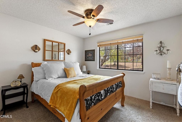 bedroom featuring a textured ceiling, ceiling fan, and carpet flooring