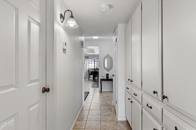 corridor with baseboards and light tile patterned floors