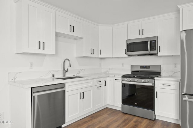 kitchen featuring light stone counters, a sink, white cabinets, and appliances with stainless steel finishes