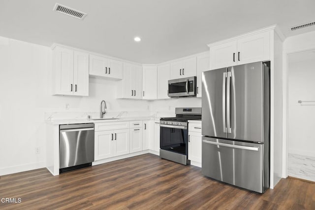 kitchen featuring baseboards, visible vents, appliances with stainless steel finishes, and a sink