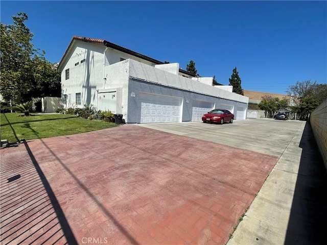 13252 Newland St A-D, Unit A-D Garden Grove, CA 92844 - view of home's exterior featuring fence, a garage, stucco siding, and a lawn