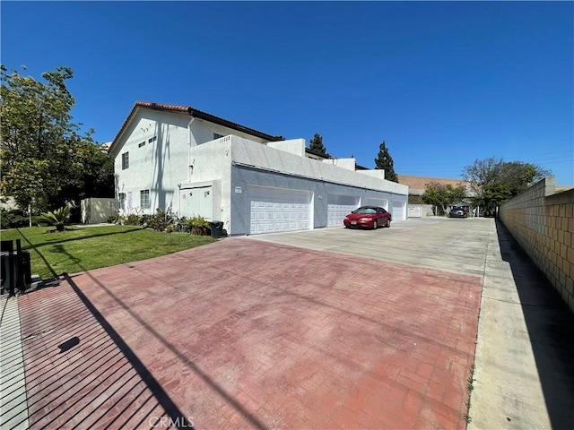 13252 Newland St A-D, Unit A-D Garden Grove, CA 92844 - view of home's exterior featuring a yard, fence, a garage, and stucco siding
