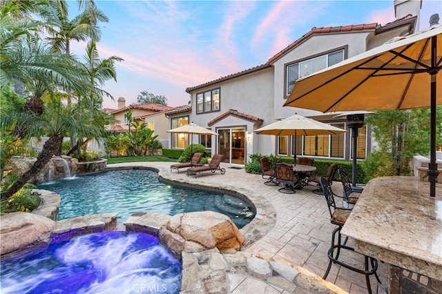 view of pool with a pool with connected hot tub and a patio area