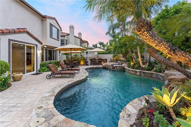 view of pool with a patio, a pool with connected hot tub, and fence