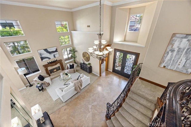 living room featuring french doors, a towering ceiling, a chandelier, and a healthy amount of sunlight