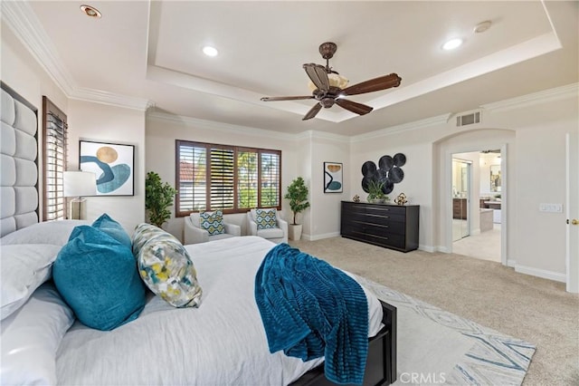 carpeted bedroom featuring a raised ceiling, baseboards, arched walkways, and visible vents