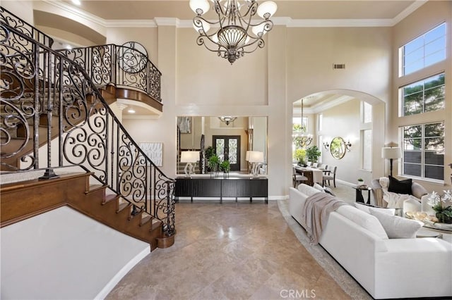interior space with visible vents, crown molding, arched walkways, a notable chandelier, and a high ceiling