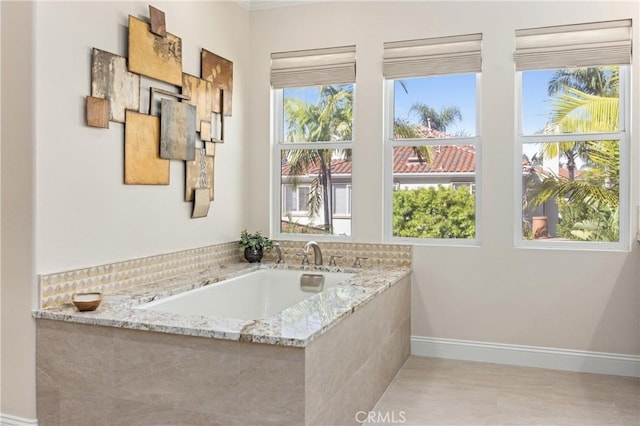 bathroom with baseboards and a healthy amount of sunlight