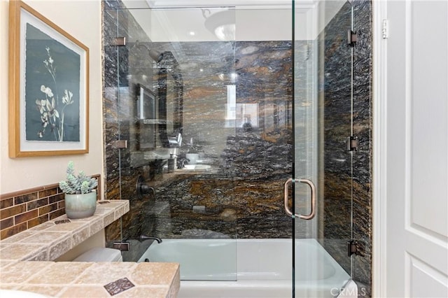 full bath with enclosed tub / shower combo, toilet, and tasteful backsplash