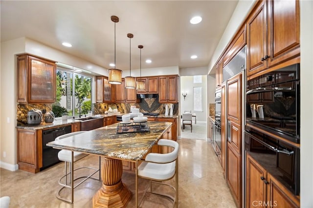 kitchen featuring brown cabinetry, black dishwasher, a kitchen bar, a center island, and a sink