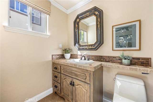 bathroom with tasteful backsplash, vanity, baseboards, toilet, and ornamental molding