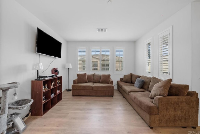 living room with visible vents and light wood-style flooring